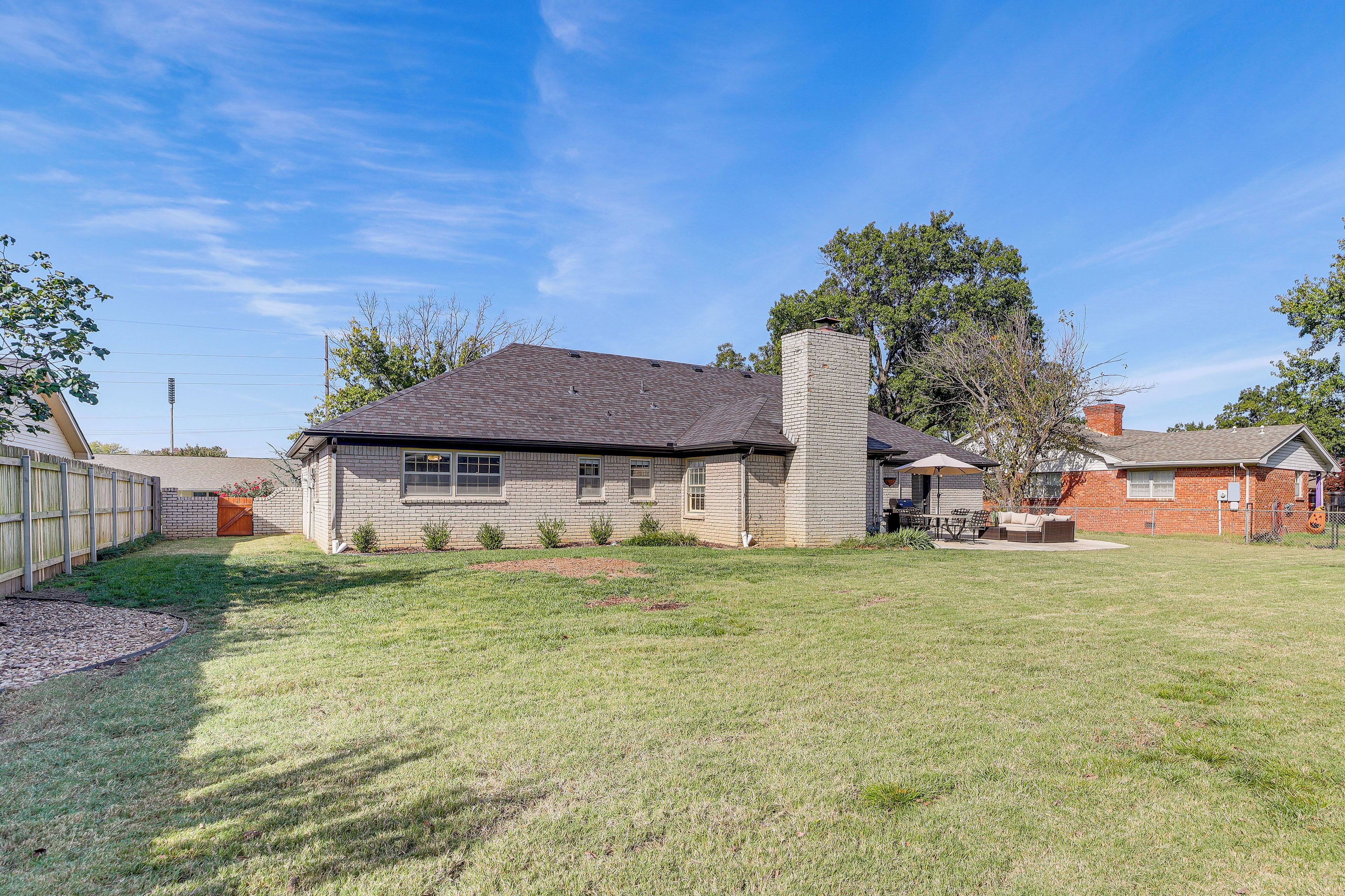 A residential house with a brick exterior, a chimney, and a well-maintained lawn.