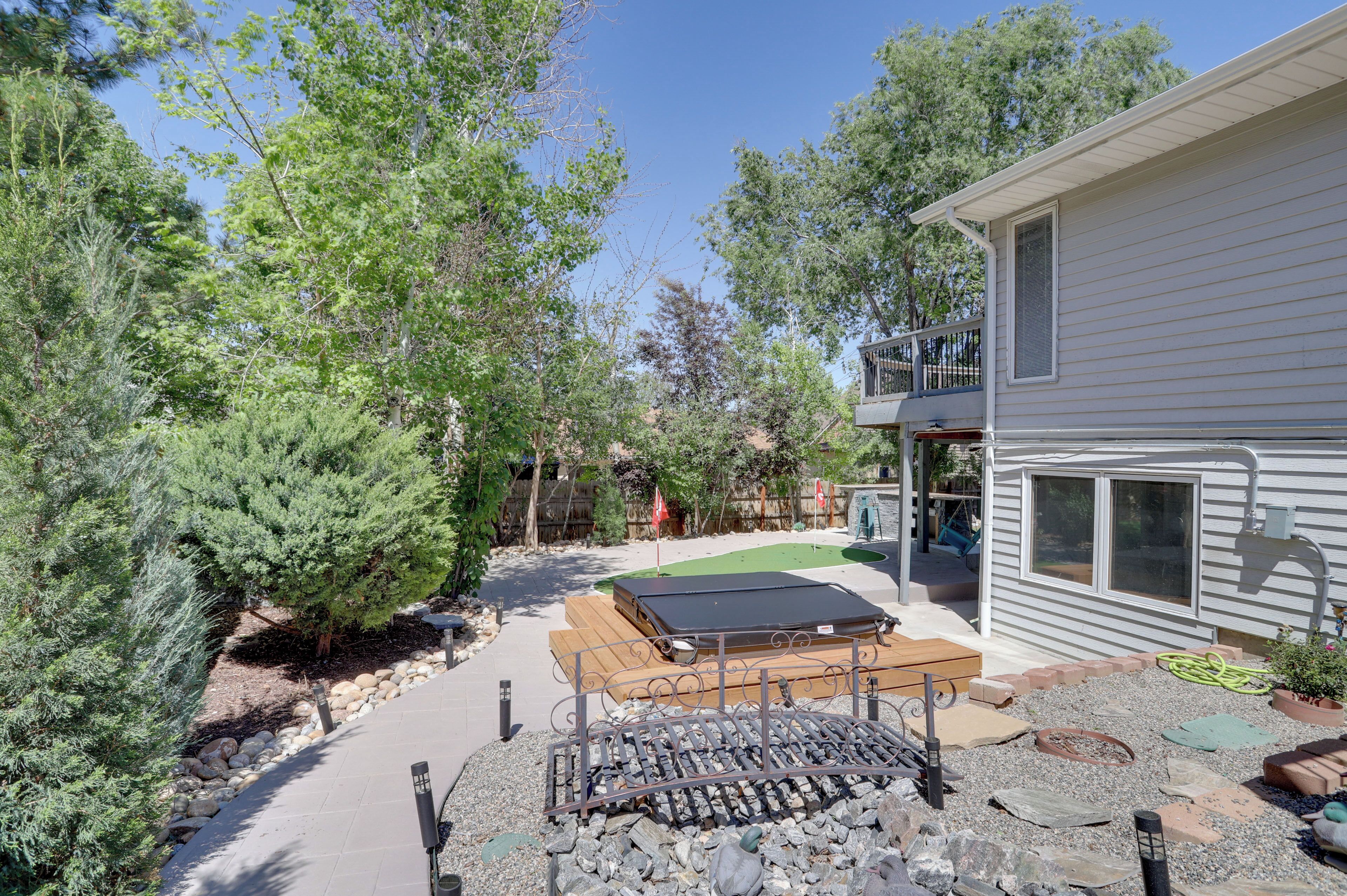 A residential property with a patio, outdoor seating, a small deck, and a house with a balcony.