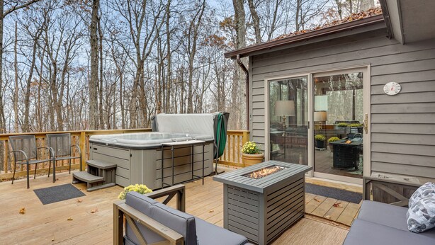 A deck with outdoor furniture, a hot tub, and a fire pit. - Grand Wintergreen Resort Home w/ Hot Tub! (Nellysford)