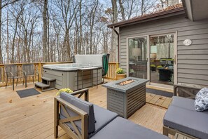 Une terrasse dotée de mobilier d’extérieur, d’un jacuzzi et d’un foyer.