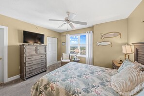 A bedroom with a bed, dresser, television, and a view of the outdoors. - 701 Twin Towers in Daytona Beach Shores, FL (Daytona Beach Shores)