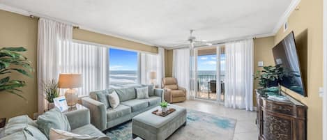 A spacious living room with a sofa set, a coffee table, and a TV on a cabinet.