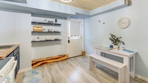 Eine Küche mit Holzböden, einer weißen Sitzbank und einer Uhr an der Wand.