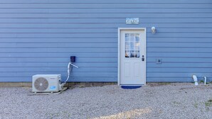 Ein Haus mit blauer Fassade, einer weißen Tür und einem Schild mit der Aufschrift 'Cazy Cove'.