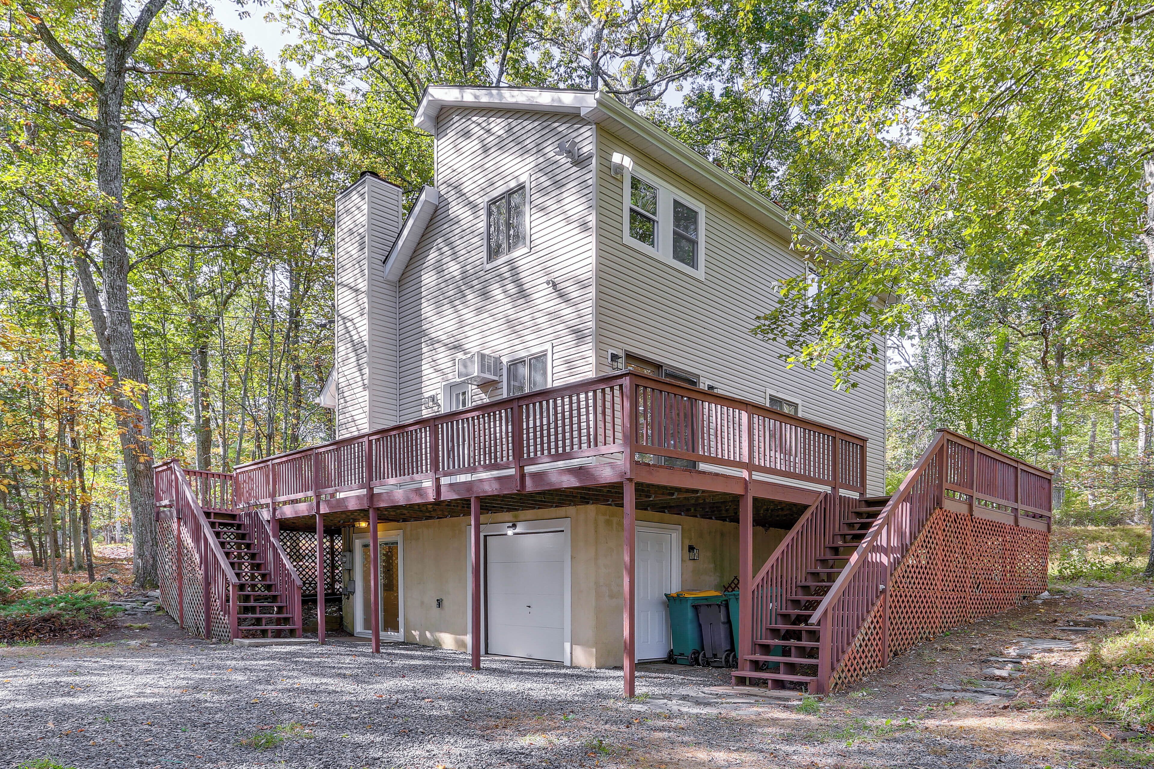 A two-story cabin with a covered porch and a staircase leading to the upper level.