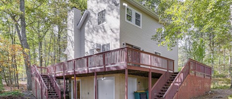 A two-story cabin with a covered porch and a staircase leading to the upper level.
