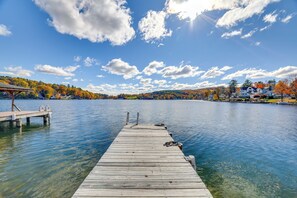A wooden pier extending into a calm lake with clear skies and autumn foliage in the background. - All-season Getaway on Lake Winola: Dock & Sunroom! (Lake Winola)