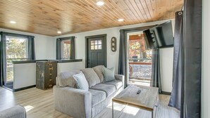 A modern living room with a sofa, a coffee table, and a wooden ceiling. - 'chène Cottage' Near Burr Oak Lake & Trailheads! (Glouster)