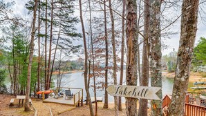 Una cabaña junto al lago con terraza, mesa de picnic y un letrero que indica el nombre 'Lachill'.