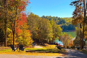 A rural setting with a dirt path, wooden benches, and a cabin in the distance.