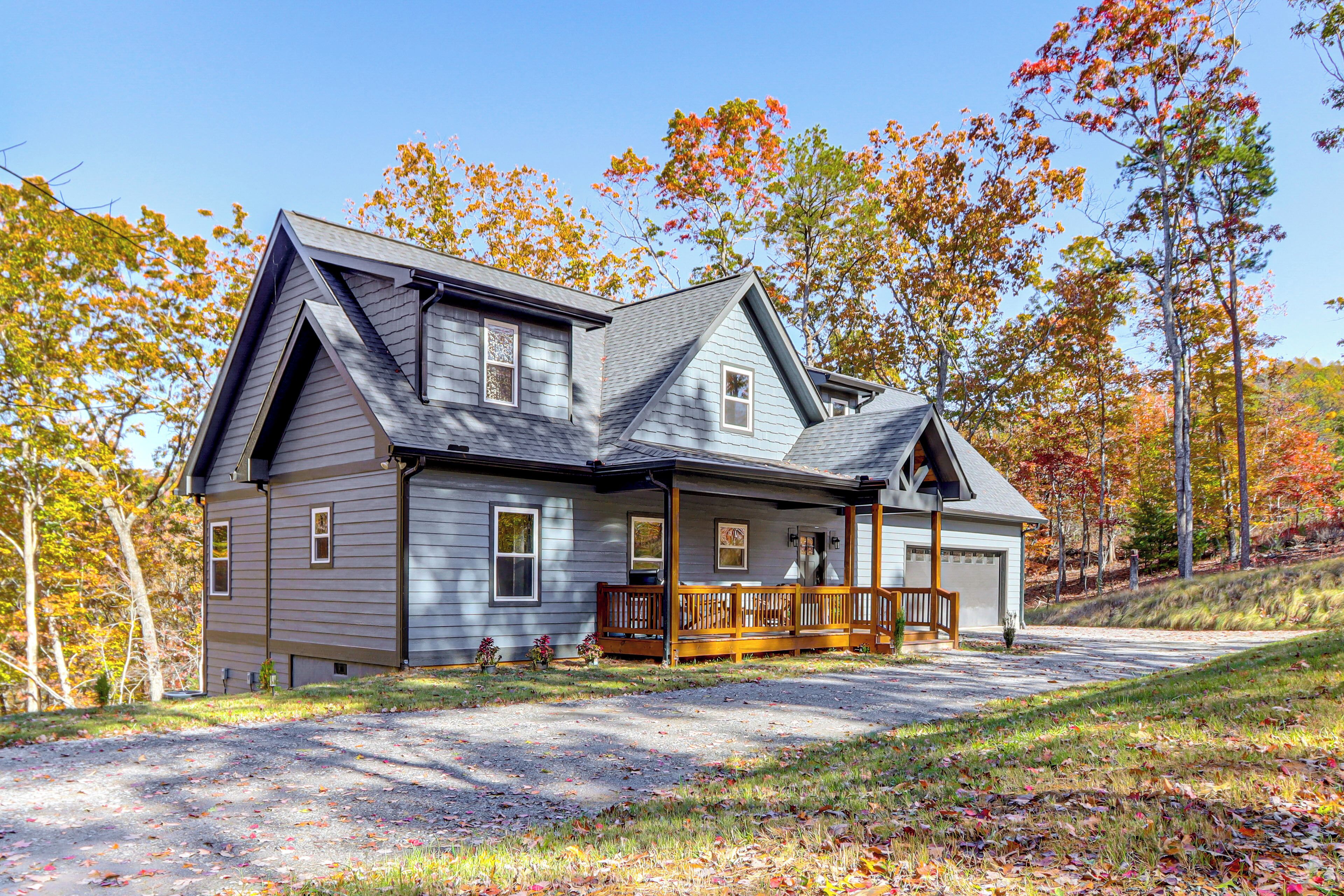 A two-story house with a front porch, garage, and a driveway leading to the entrance.