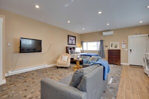 A living room with a flat-screen TV, a sofa, a chair, a lamp, and a bed. - Cozy Couple's Retreat 5 Mi to Garden of the Gods! (Colorado Springs)