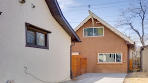A two-story house with a brown exterior, a concrete driveway, and a wooden fence. - Cozy Couple's Retreat 5 Mi to Garden of the Gods! (Colorado Springs)