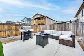 A backyard with a barbecue grill, a wicker sofa, and a wooden fence. - 8 Mi to Usafa! Hot Tub Haven in Colorado Springs (Colorado Springs)