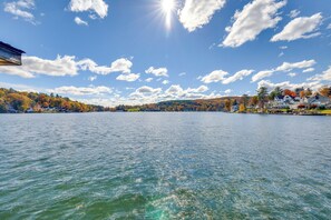 Un lac aux eaux limpides, entouré de maisons et d’arbres aux feuilles d’automne.
