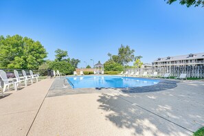 Une piscine avec des chaises longues et un kiosque en arrière-plan.