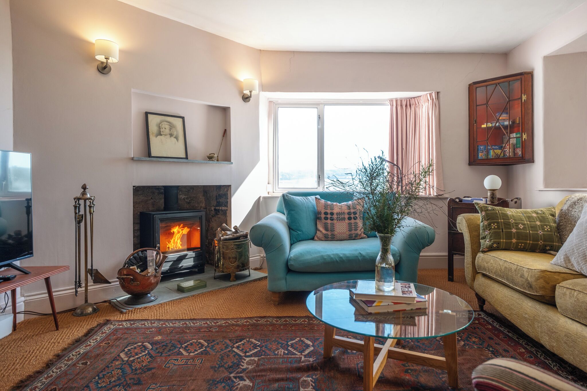 A cozy living room with a fireplace, a sofa, a coffee table, and a television.