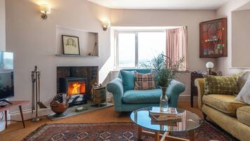 A cozy living room with a fireplace, a sofa, a coffee table, and a television.
