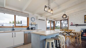 Cozinha moderna com uma ilha grande, banquetas e lareira.