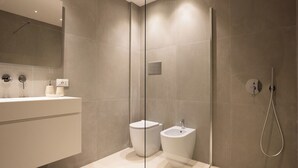 A modern bathroom with a glass shower enclosure, a toilet, and a bidet. - Luxury Freedom Juno (Palermo)