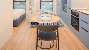 Una moderna camera d'albergo con zona pranzo, un letto e vista sulla città.