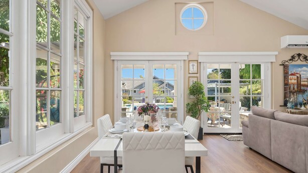 A dining area with a table set for four, large windows, and a view of the outdoors. - Luxury LA Garden Estate Private Pool Hottub Tennis (La Habra)