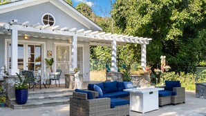 A covered patio with wicker furniture and a pool. - Luxury LA Garden Estate Private Pool Hottub Tennis (La Habra)