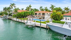 A marina with boats docked, a swimming pool, and a house with a red roof. - Deep Blue Waterfront Gem Pool Kayaks Dock (Key Colony Beach)