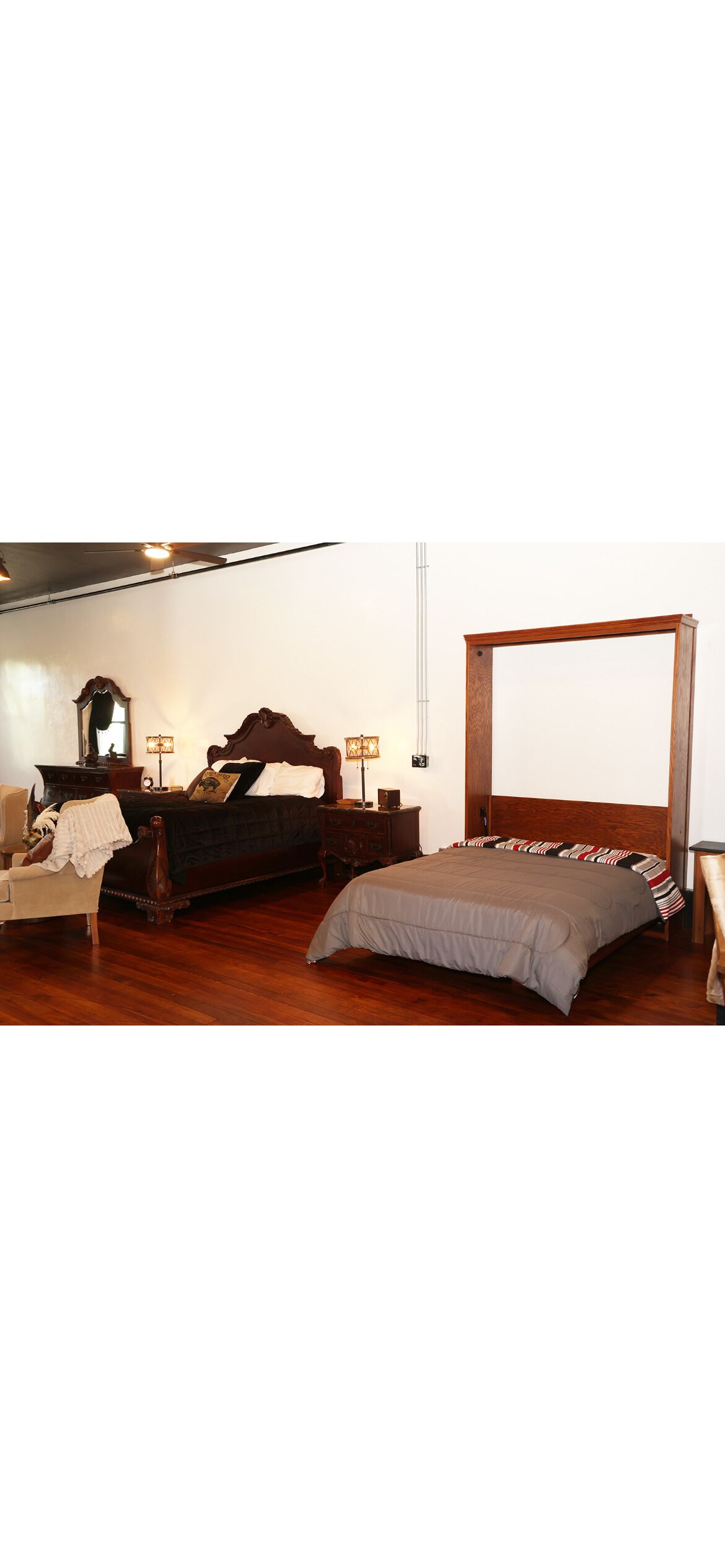 A bedroom with a large bed, a chair, a dresser, and a mirror.