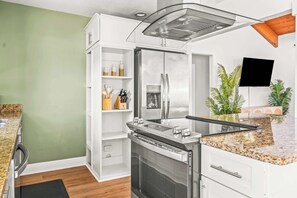 Eine moderne Küche mit Einbauofen, Edelstahlgeräten und einer Arbeitsplatte aus Granit.