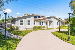 A two-story house with a driveway leading to the front door.