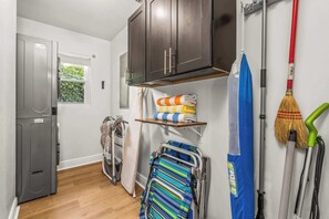 A compact kitchen with a refrigerator, cabinets, a window, and a drying rack. - Heated Pool Days & Palm Nights – Modern West Palm Vibes (West Palm Beach)
