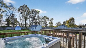 A hot tub on a wooden deck with a wooden fence and trees in the background. - Cozy Retreat With Hot Tub In Peaceful Goshen 4 Bedroom Home (Goshen)