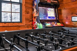 A foosball table in a room with wooden walls and a window. - Pearl's Mountain Retreat 3 Bedroom Cabin (Sevierville)