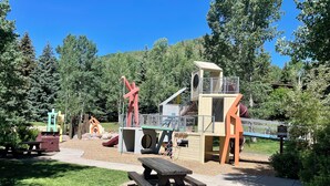 Une aire de jeux avec des toboggans, des structures d’escalade et des tables de pique-nique.