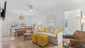 A bright, white-walled room with a sofa, ottomans, and wicker chairs. - Sunny 3BR Near the Beach at Palm Court  (#17) (North Myrtle Beach)