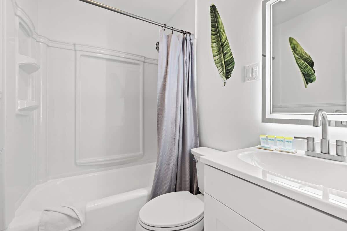 A bathroom with a bathtub, toilet, and sink.