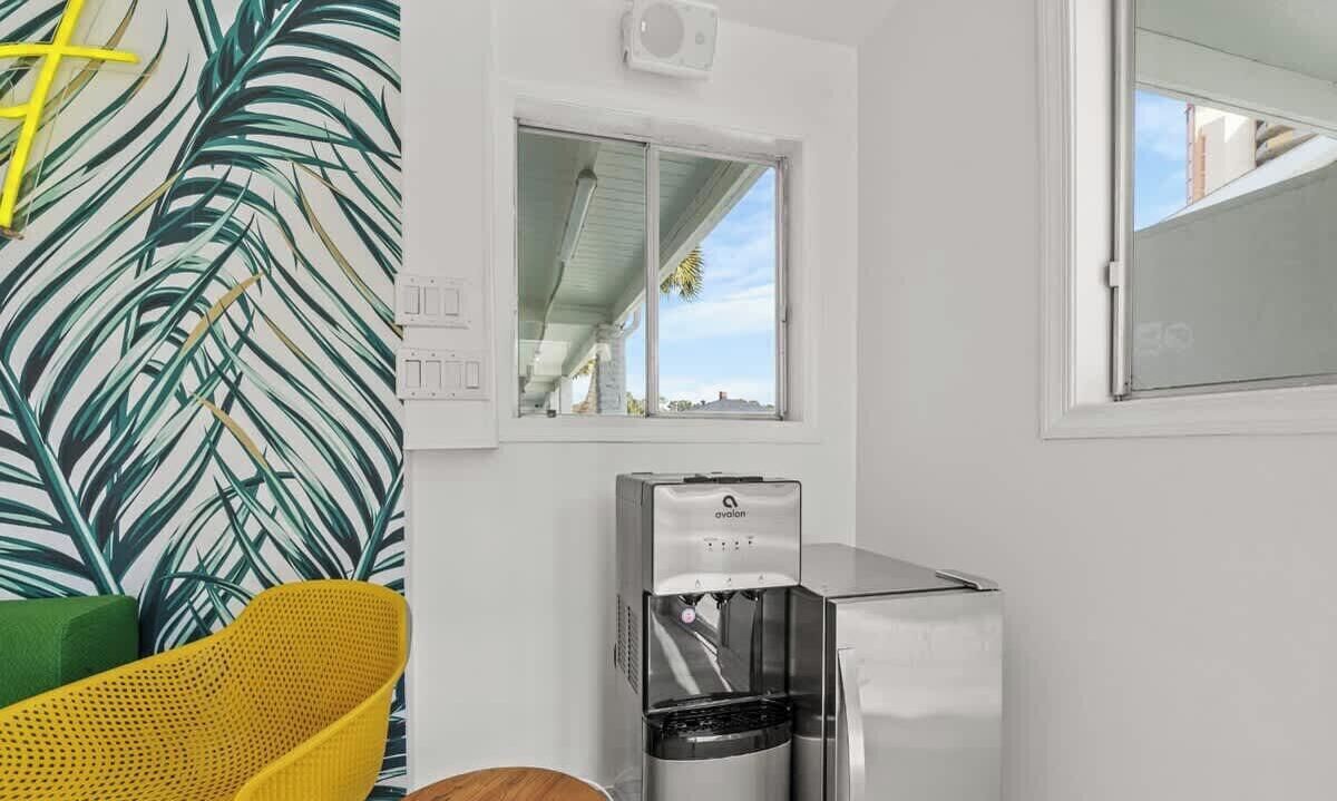 A shared amenity lounge with a water dispenser, a window, and a view of the outside.