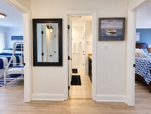Ein Hotelzimmer mit einem Bett, einem Spiegel, einer Tür zu einem Badezimmer und einem Bild an der Wand.