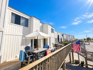 A row of mobile homes with outdoor patios, a wooden deck, and an American flag. - Captain Chris at South Winds | Across from Beach + Walk to Gulf Shores Fun (Gulf Shores)