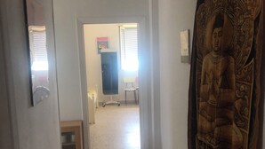A hallway with a Buddha statue, a desk, and a chair. - House by the sea (Lido Chiatona-Stazione di Palagiano)