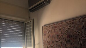 A room with a bed, a patterned rug, a window with blinds, and a chair. - House by the sea (Lido Chiatona-Stazione di Palagiano)