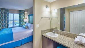Une chambre d’hôtel avec un lit, une salle de bain comprenant un lavabo et un miroir, et une vue sur l’extérieur.