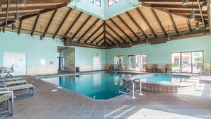 Una piscina interior con techo alto y suelo de baldosas.