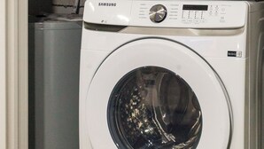 Dos lavadoras Samsung apiladas en un cuarto de lavado.