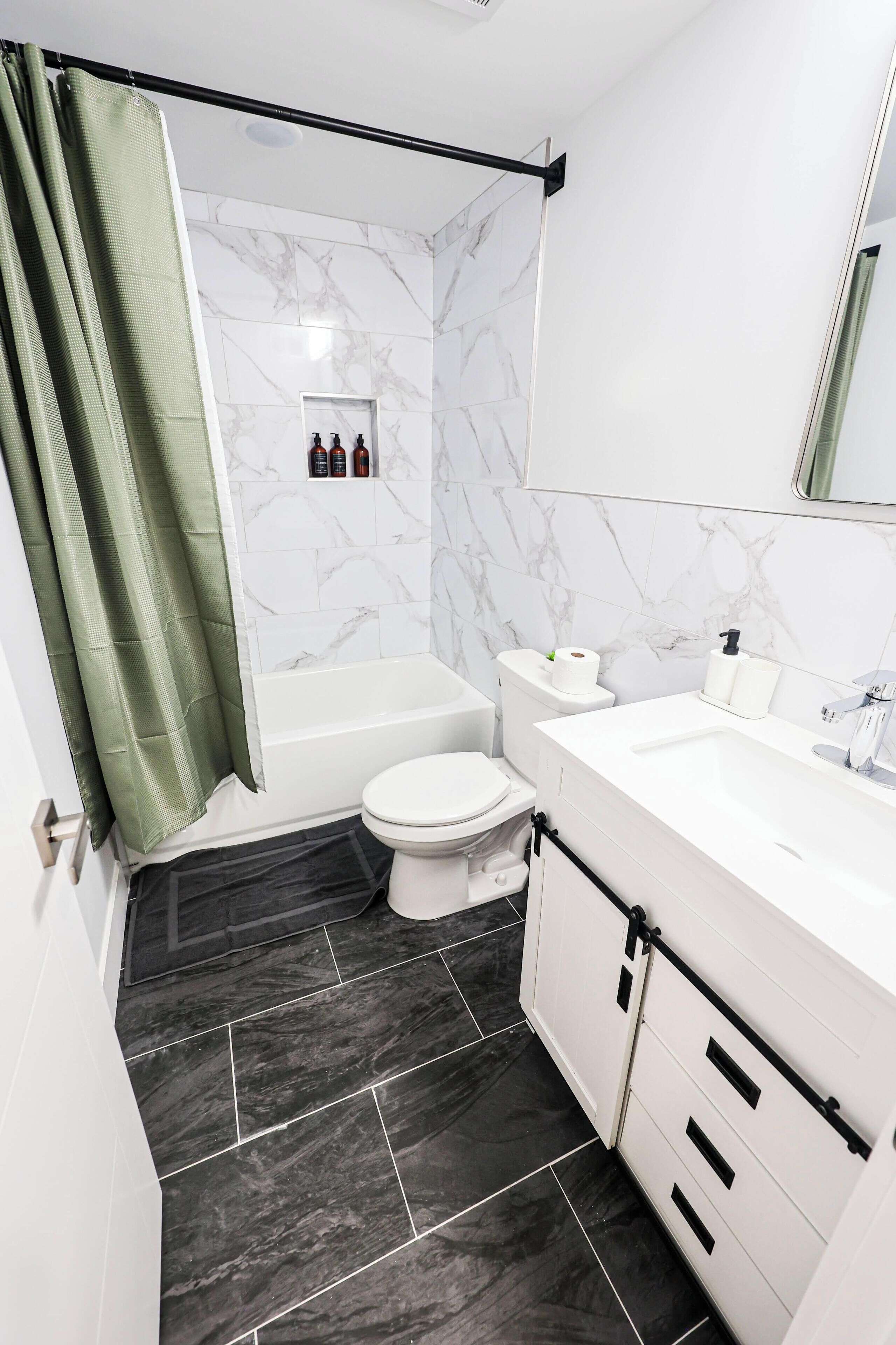 Un baño con ducha, inodoro y lavabo.