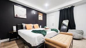 Et moderne soveværelse med seng, natbord og bænk.