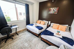 A hotel room with two beds, a desk, and a chair. - Modern 2BR near Philly Zoo & UPenn! Features central air, in-unit laundry, sleek kitchen & sleeps 6. Quick access to I-76/676 & top attractions. (Philadelphia)