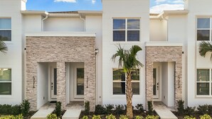 A modern two-story house with stone accents and large windows.