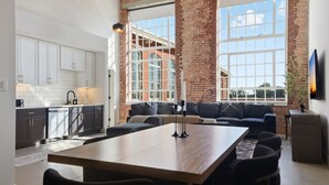 A modern kitchen with white cabinets and a dining area with a wooden table and black chairs. - Warm and Inviting Abode (Greenville)